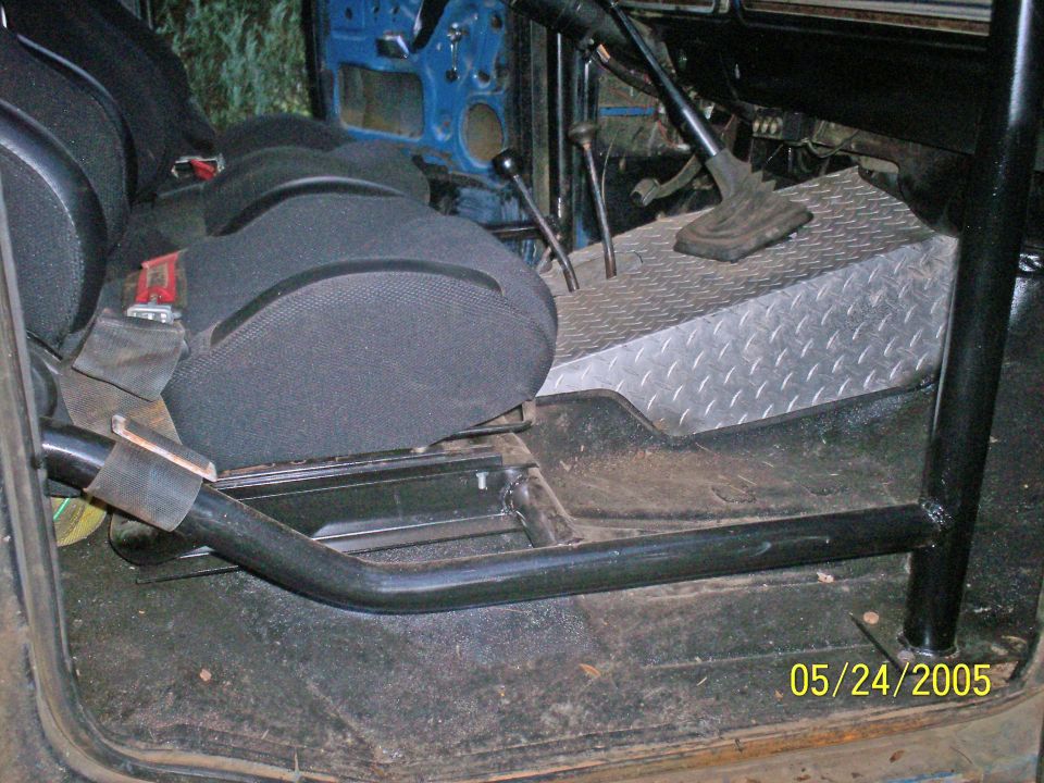 Bronco interior with black seat, roll cage bars, and diamond-plate floor