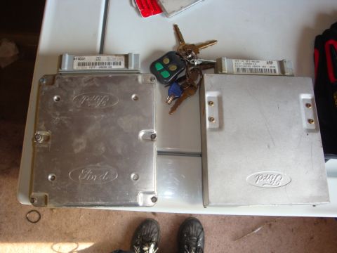 1989 Ford Bronco - Two Ford electronic control units and a set of keys are laid out on a white surface.