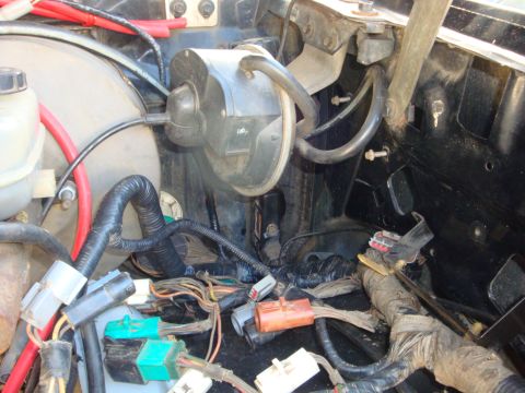 1989 Ford Bronco - Close-up view of the engine bay wiring harness and brake booster assembly.