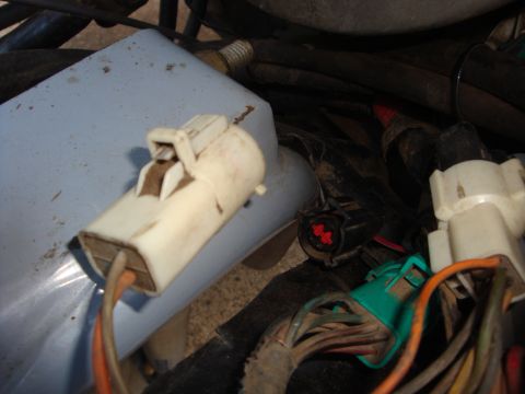 1989 Ford Bronco - Engine bay wiring harness connectors are visible, with orange and brown wires leading into one connector.