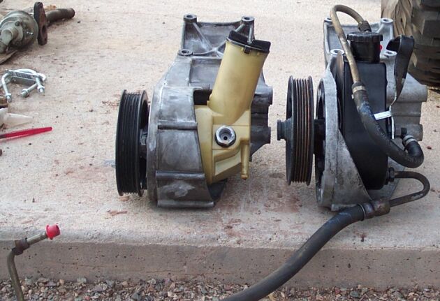 Two automotive components with serpentine pulleys and reservoir on concrete