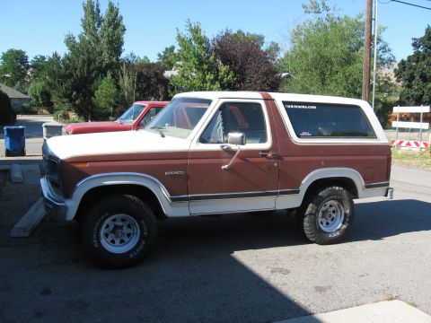 1981 Ford Bronco - A two-tone brown and white Ford Bronco is parked on a sunny day.