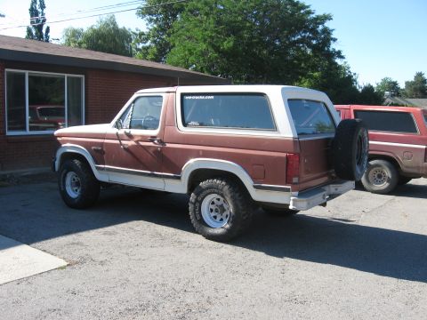 1981 Ford Bronco - This 1981 Ford Bronco is seen from the rear quarter angle, a two-tone brown and white paint scheme and a spare tire on the back.