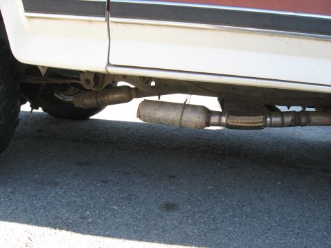 1981 Ford Bronco - Undercarriage view of a vehicle's exhaust system, including a muffler and flex pipe.