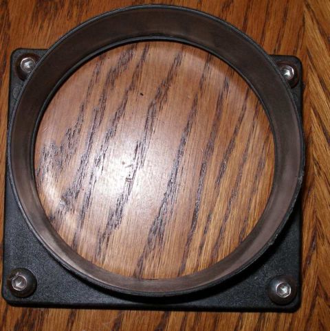 1997 Ford Taurus - This is a black air intake housing with a circular opening, shown against a wooden background.