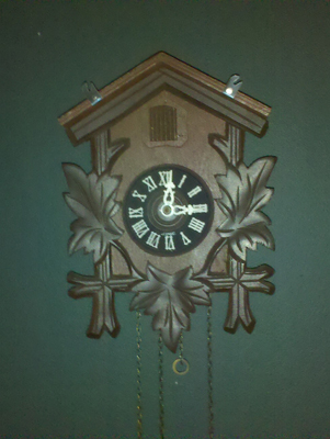 1978 Ford Bronco - A wooden cuckoo clock with decorative leaves and chains hangs on a teal wall.