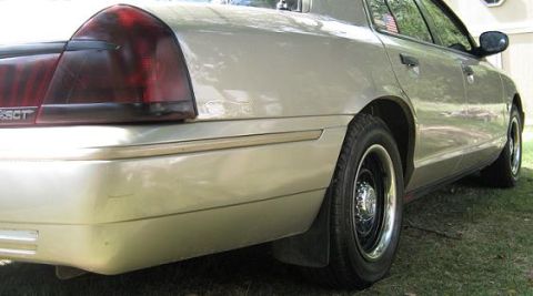 2000 Mercury Grand Marquis - Rear view of a tan 2000 Mercury Grand Marquis, showing its distinctive taillight and body lines.