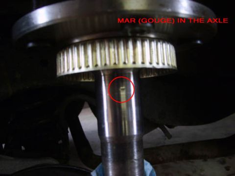 2002 Ford Crown Victoria - A close-up view highlights a mar or gouge on the vehicle's axle, with accompanying text identifying the damage.