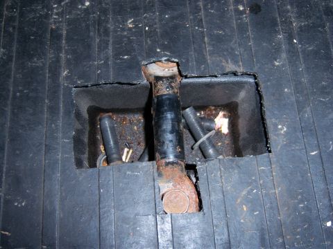 1996 Ford Bronco - Close-up of a child seat tether anchor mechanism integrated into a black ribbed floor mat.
