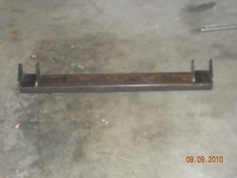 1989 Ford Bronco - A metal bracket with U-shaped mounts is shown on a concrete surface.