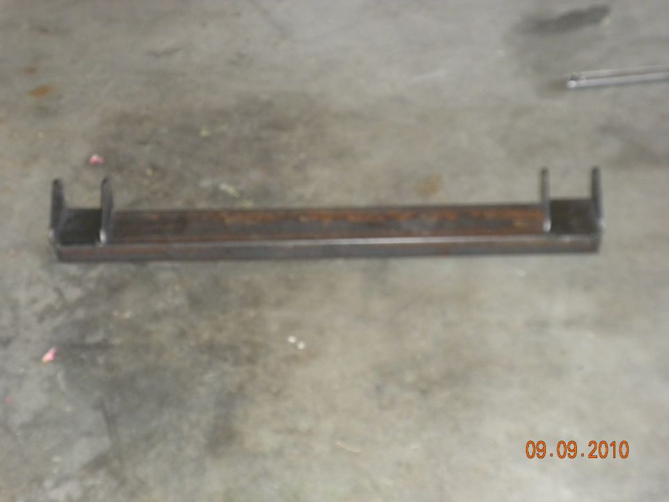 Metal bracket with two U-shaped mounts on a concrete floor