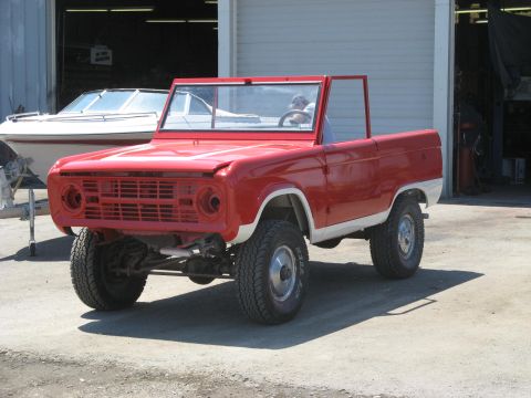 1966 Ford Bronco - This red Ford Bronco is undergoing some work in front of a garage.