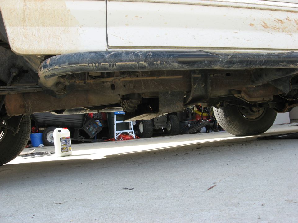 White 1994 Ford Bronco underside, showing frame, suspension, and exhaust pipe