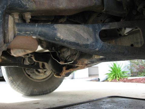 1994 Ford Bronco - A close-up view of the vehicle's undercarriage, focusing on the suspension and a tire.