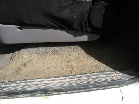 1994 Ford Bronco - Close-up view of the interior door sill and carpet, showing wear and dirt. The registry claims this is a 1994 Ford Bronco.
