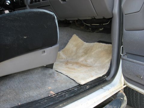 1994 Ford Bronco - Passenger side interior view of a vehicle, focusing on the floor mat and seat base.