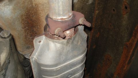 1988 Ford Bronco - This image shows a section of a vehicle's exhaust system, including a clamp and a catalytic converter.