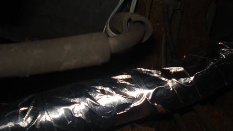 1988 Ford Bronco - Vehicle exhaust pipe and heat shielding are visible in this close-up shot.