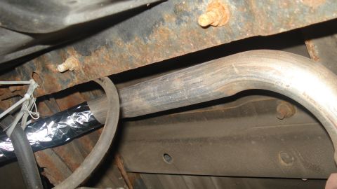 1988 Ford Bronco - Underbody view shows rusted frame components and a section of the exhaust system.