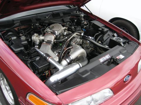 1992 Ford Crown Victoria - Customized engine bay of a red Ford Crown Victoria, a prominent turbocharger and polished intake piping.