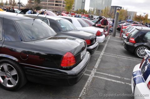 1992 Ford Crown Victoria - Several cars are parked in a lot, with the rear of a black Ford Crown Victoria in the foreground.
