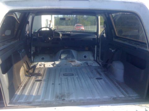 1993 Ford Bronco - The interior of a white SUV is visible, with the dashboard and empty cargo area exposed.