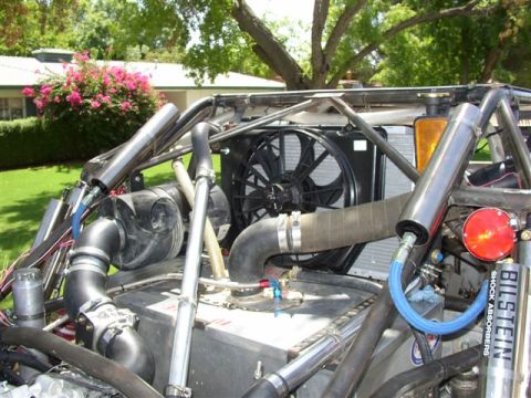 1993 Ford Taurus - Close-up view of the engine bay of a custom off-road vehicle, showing various mechanical components and suspension parts.