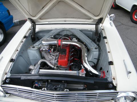 1967 Ford Fairlane - Engine bay of a 1967 Ford Fairlane, a V8 engine with custom intake and red valve covers.