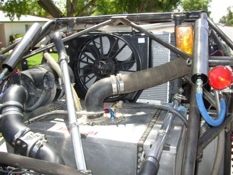1993 Ford Taurus - The engine bay shows a complex arrangement of hoses, a fan, and a radiator, with some text visible on a metal tank.