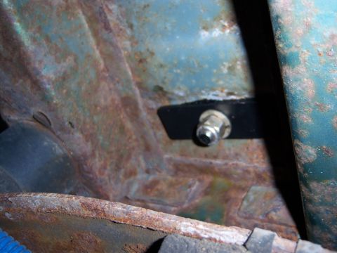 1996 Ford Bronco - This image shows a close-up of a rusted vehicle frame with a bolt and bracket. The text 'SUPERMOTORS.NET' is visible at the bottom right.