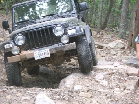1996 Ford Bronco - A black Jeep Wrangler Rubicon navigates a challenging rocky trail.
