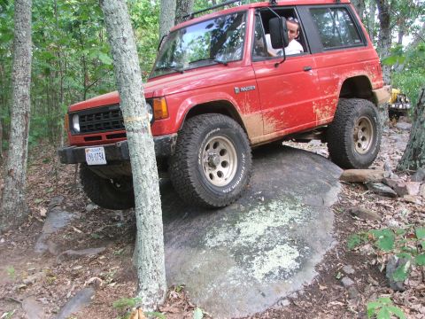 1996 Ford Bronco - A red Mitsubishi Montero navigates a rocky trail with another vehicle visible in the background.