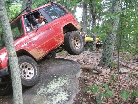1996 Ford Bronco - Off-road vehicles navigate a rocky trail in a forest setting.