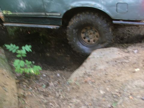 1996 Ford Bronco - This vehicle appears to be off-roading, with its tire on a rocky incline and the body close to the ground.