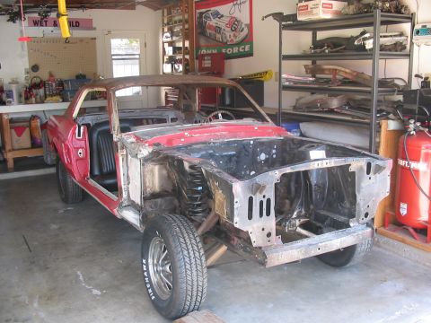1968 Ford Mustang - A car body undergoing restoration in a garage, with parts removed and the interior exposed.