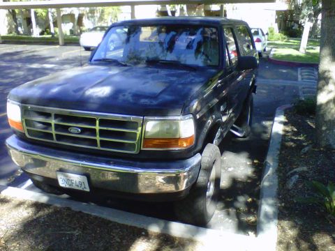 1995 Ford Bronco - This 1995 Ford Bronco is parked in a lot, showing its front grille and license plate.