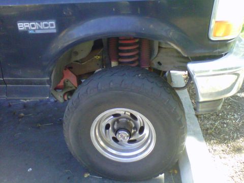 1995 Ford Bronco - Close-up of the front wheel and fender area of a 1995 Ford Bronco XL.