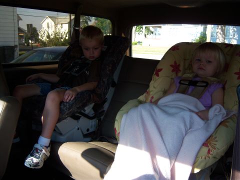 1996 Ford Bronco - Two children are secured in car seats in the back of a vehicle.