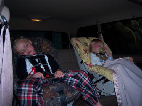 1996 Ford Bronco - Two children are asleep in car seats in the back of a vehicle.