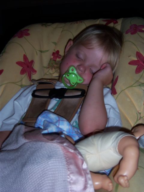 1996 Ford Bronco - A child sleeps soundly in a car seat, complete with a pacifier and a doll nearby.