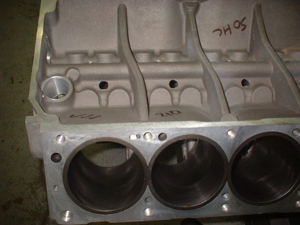 Bare aluminum V8 engine block with honed cylinder bores and SOHC marked in red