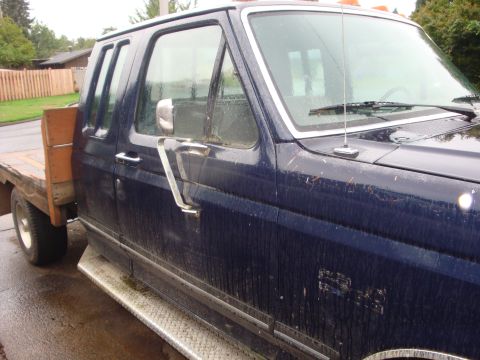 1989 Ford Bronco - This Ford F-250 Super Duty truck features a crew cab and a flatbed, seen from the front quarter angle.