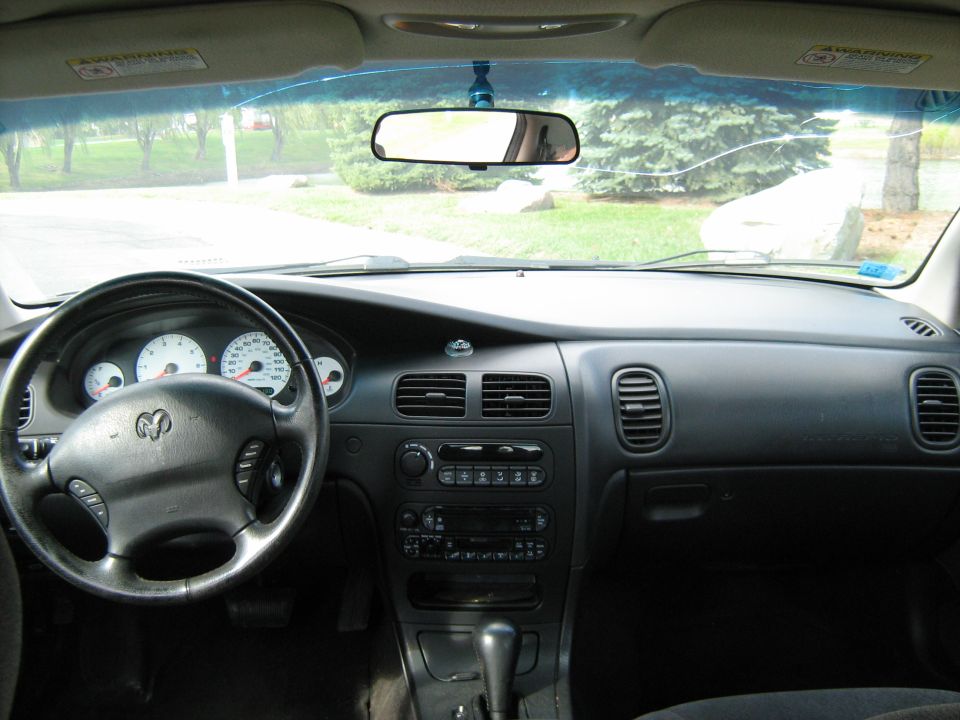 Interior view of a car dashboard with steering wheel, gauges, and center console. Supermotors.net watermark visible