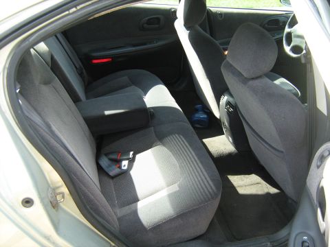 1988 Mercury Grand Marquis - The interior of a sedan is viewed from the rear passenger side, revealing gray cloth seats and door trim.