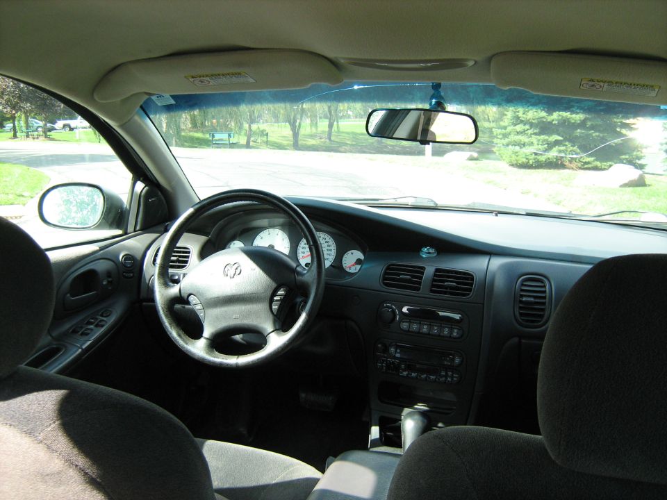 Gray Dodge sedan interior showing steering wheel, white-faced gauges and center stack