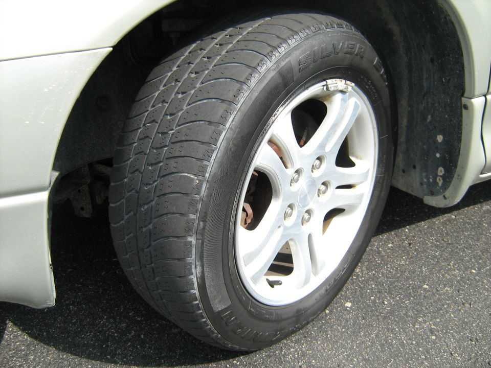 Close-up of a five-spoke alloy wheel with Kumho tire on a silver car