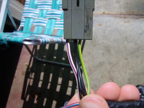 1988 Ford Crown Victoria LTD - A hand holds a gray electrical connector with multiple colored wires attached.