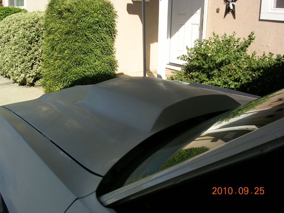 Gray car hood with a large aftermarket scoop, seen from the passenger side