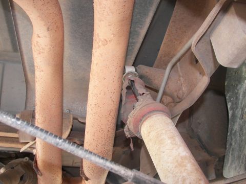 1995 Ford Bronco - Underbody view shows rusted exhaust pipes and a driveshaft with a damaged boot.