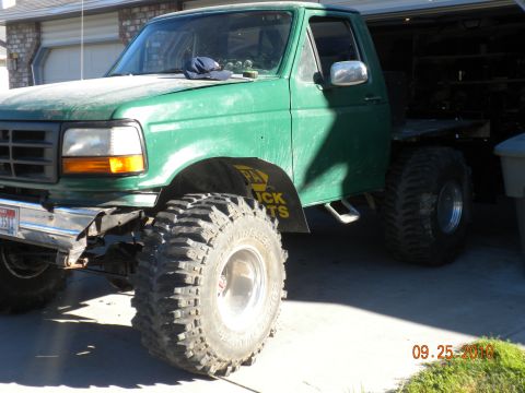1989 Ford Bronco - This green flatbed truck appears to be from the early 1990s, not a 1989 Bronco.